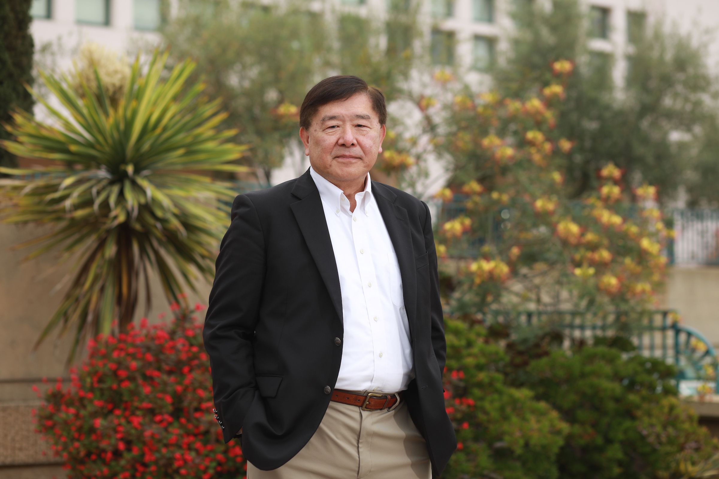 Man standing in front of Manchester Hall with the Library in the background